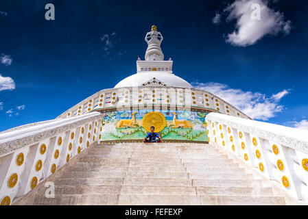 Leh, Ladakh - Agosto 24, 2015: la vista di un giovane ragazzo meditando di fronte Shanti stupa. Foto Stock