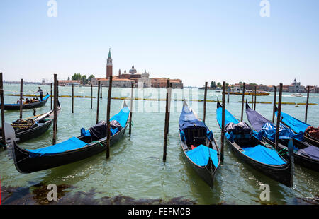 Una fila di gondole nere ormeggiate sulla laguna veneta vicino a Piazza San Marco a Venezia. Gondola Foto Stock