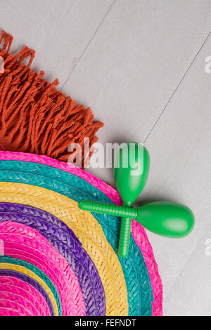 Sombrero messicano, coperta e coppia di maracas su uno sfondo di legno. Foto Stock