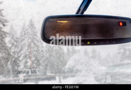 Vista attraverso il parabrezza auto in inverno nevoso giorno sulla strada Foto Stock