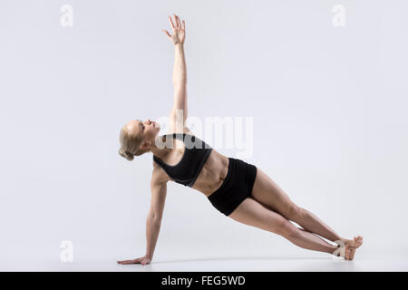 Sporty bella giovane donna a praticare yoga, facendo listone laterale postura, posa di Vashista, Vasisthasana, lavorando da indossare Foto Stock