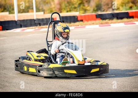 Bambina è la guida Go-kart auto in un parco giochi racing via Foto Stock