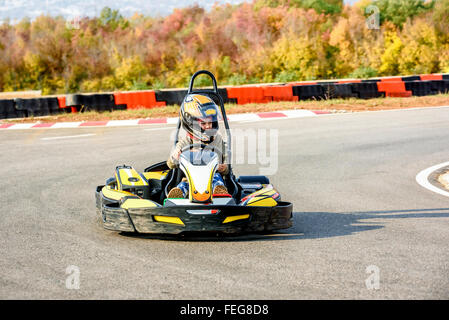 Bambina è la guida Go-kart auto in un parco giochi racing via Foto Stock