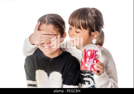 Bambina dando amore a sorpresa regalo al suo amico con sfondo bianco Foto Stock