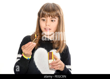 8 anno vecchia ragazza giocare con fiammiferi isolato su bianco Foto Stock