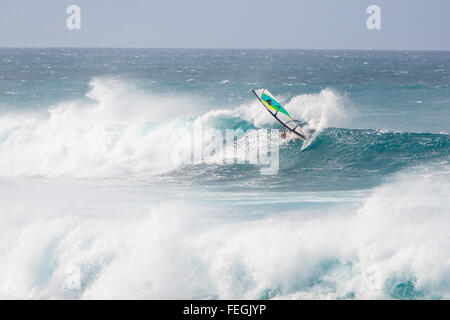 Un windsurf Cavalca le onde nella parte anteriore del Hoʻokipa beach sull'isola di Maui, Hawaii (USA) Foto Stock