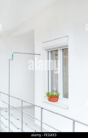 Lo stretto passaggio al portico anteriore. Luce bianca sulla terrazza al primo piano di un moderno design. con bianco luminoso con finestra in PVC a Foto Stock