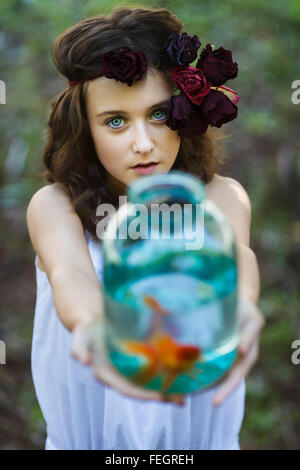 Ragazza giovane con oro di pesce in estate Foto Stock