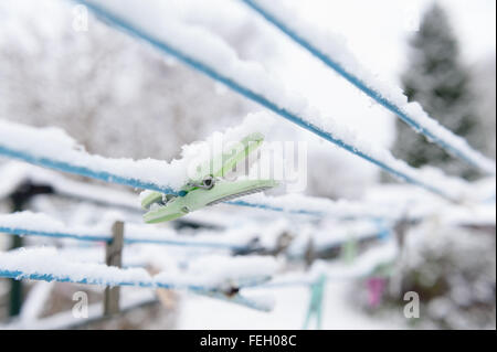 Fila di vecchia nuova plastica legno mollette su una linea di lavaggio con fuori fuoco sfondo pronto per il lavaggio di un quotidiano chore Foto Stock