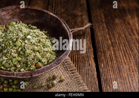 Il Pepe verde (schiacciate) su un vecchio tavolo di legno (close-up shot) Foto Stock