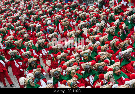 Elzach, Germania. 07 feb 2016. Centinaia di persone che indossano costumi prendere parte al tradizionale "chuttigsprung' (lit. Schuttig salto) sfilata di carnevale nella Foresta Nera città di Elzach, Germania, 07 febbraio 2016. Il Schuttig è un tradizionale carnevale Elzach figura. Egli indossa un rosso shaggy tuta e un grande cappello di paglia con gusci di lumaca. Foto: PATRICK SEEGER/dpa/Alamy Live News Foto Stock