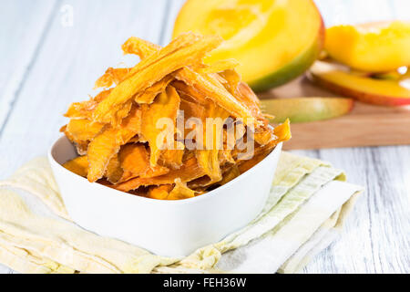 Una piccola ciotola con secchi fette di mango e frutta fresca Foto Stock