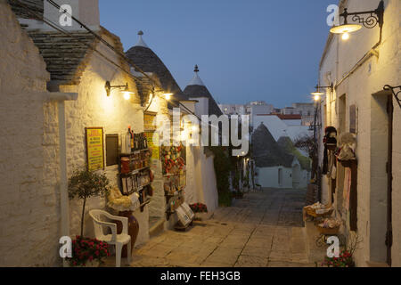 Strada e negozi nel quartiere di trulli Rione Monti ad Alberobello Puglia, Italia Foto Stock