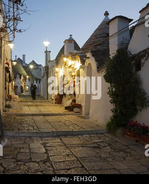 Strada e negozi nel quartiere di trulli Rione Monti ad Alberobello Puglia, Italia Foto Stock