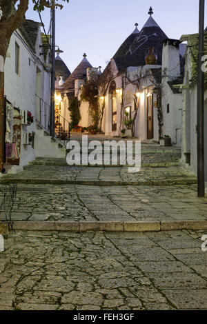 Strada e negozi nel quartiere di trulli Rione Monti ad Alberobello Puglia, Italia Foto Stock