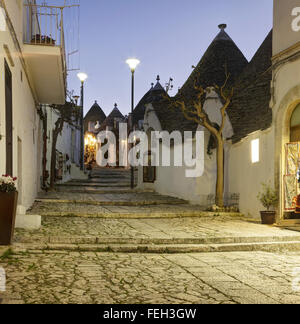 Strada e negozi nel quartiere di trulli Rione Monti ad Alberobello Puglia, Italia Foto Stock