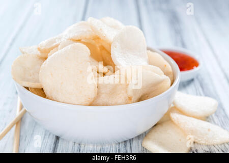 Fresche fatte cracker ai gamberi (krupuk) su sfondo di legno Foto Stock