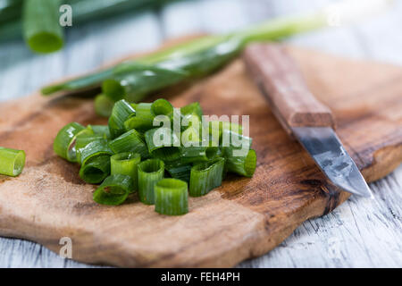 Lo scalogno (fresco tagliato) come close-up shot su sfondo di legno Foto Stock