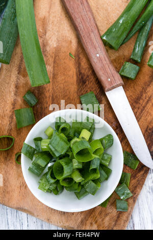 Lo scalogno (fresco tagliato) come close-up shot su sfondo di legno Foto Stock