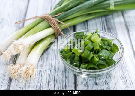 Lo scalogno (fresco tagliato) come close-up shot su sfondo di legno Foto Stock