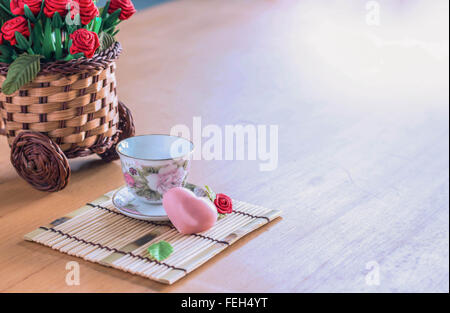 Cuore rosa e una tazza di tè su un bambù Foto Stock