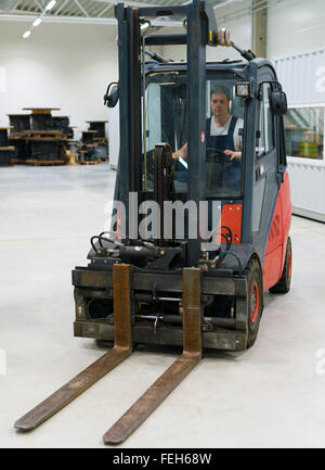 Operatore carrello elevatore a forche lavora in magazzino. Foto Stock