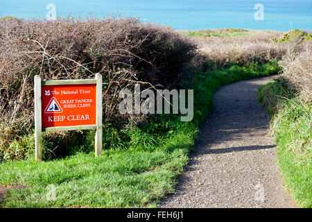 Segno di avvertimento di pericoli al mare drammatico pile a Bedruthan Steps sulla costa nord della Cornovaglia, England, Regno Unito Foto Stock