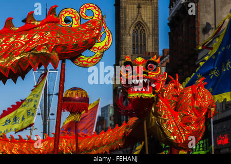 Il vivido arancione Drago colorato visto che danzano intorno alle strade principali che compongono il Liverpool Chinatown. Foto Stock