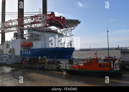 Liverpool waterfront con il Liverpool barca pilota nella parte anteriore di una nave tedesca equipaggiato con enormi gru e attrezzatura di perforazione. Foto Stock