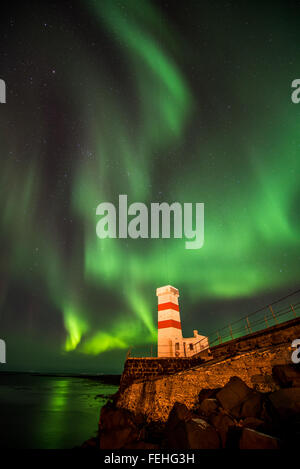 Aurora Boreale in un cielo invernale su un faro in Islanda Foto Stock