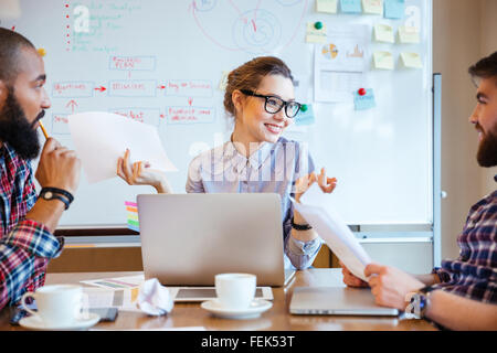 Gruppo multietnico di felice giovani studenti seduti in classe e studiare insieme Foto Stock