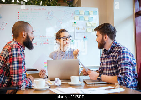 Gruppo serio di giovani che lavorano sulla riunione di affari insieme Foto Stock