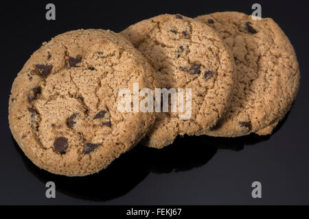 Biscotti / cookies sul plain nero, riflettente, sfondo - metafora per computer / browser / cookie web & 'che veramente si prende il biscotto' Idiom. Foto Stock