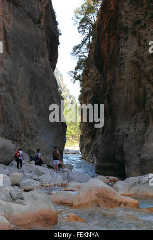 Creta, scenario in Samaria gulch, piccolo ruscello dal gulch, viaggiatore andare attraverso il cancello di ferro Foto Stock