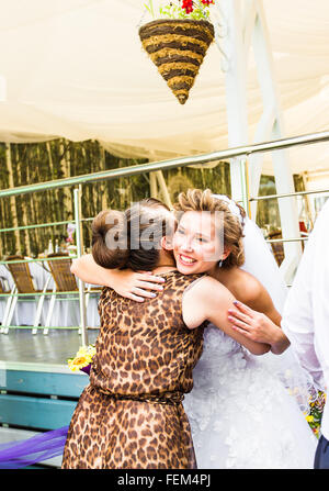 Sposa abbracciando la sorella sul giorno di nozze Foto Stock