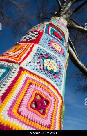 Guerriglia della maglia - closeup di coloratissimi modelli di lana intorno a un tronco di albero in Olympiapark a Monaco di Baviera, Germania Foto Stock