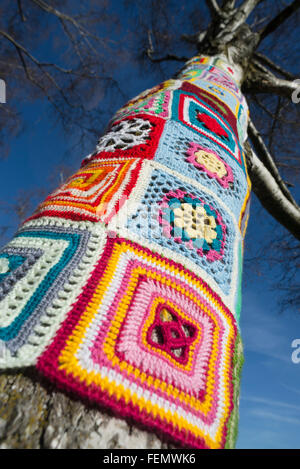 Guerriglia della maglia - closeup di coloratissimi modelli di lana intorno a un tronco di albero in Olympiapark a Monaco di Baviera, Germania Foto Stock