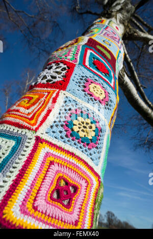 Guerriglia della maglia - closeup di coloratissimi modelli di lana intorno a un tronco di albero in Olympiapark a Monaco di Baviera, Germania Foto Stock