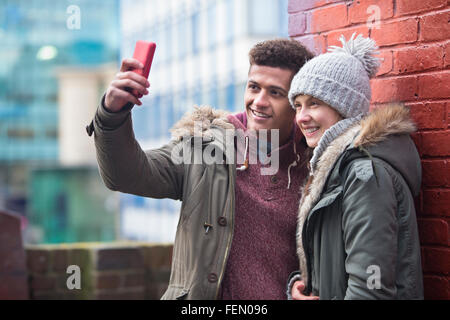 Coppia giovane prendendo un selfie nella città. Foto Stock