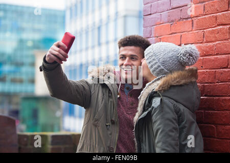 Coppia giovane prendendo un selfie nella città. Foto Stock