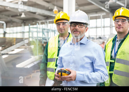 Ritratto fiducioso ingegnere e lavoratori in indumenti da lavoro protettiva Foto Stock