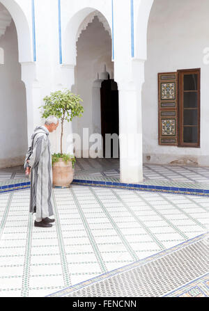 Nord Africa Marocco Marrakech Medina Marrakech Marrakesh uomo in tradizionale abiti djellaba gallabea jillaba con cappuccio jillaba marocchino Bahia Palace Foto Stock