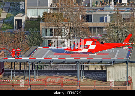 THUN, Svizzera - 1 gennaio 2014: elicottero e paziente sul tetto dell'ospedale della città di Thun. Thun è una città nel cantone di Berna in Svizzera. Ci è una vista delle Alpi bernesi. Foto Stock