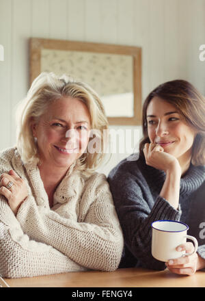 Ritratto sorridente madre e figlia in maglioni di bere il caffè Foto Stock