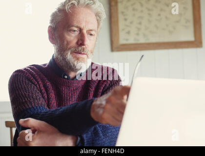 Uomo serio utilizzando laptop Foto Stock