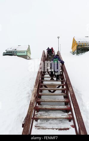 Vista posteriore di persone che si muovono su scala di legno a Ilulissat Foto Stock