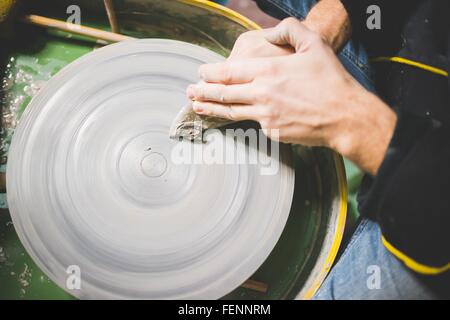 Vista aerea della metà adulto mans pulizia delle mani ruota in ceramica Foto Stock