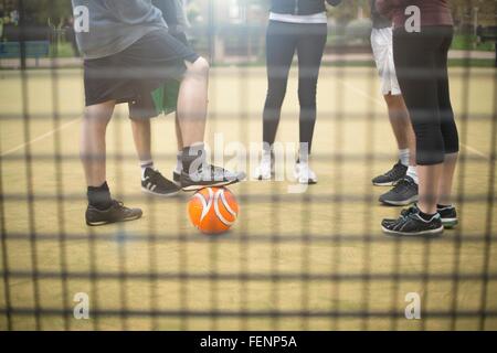 Gruppo di adulti in piedi su urban campo sportivo, sezione bassa Foto Stock