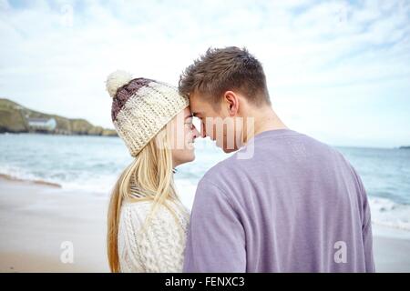 Romantico coppia giovane faccia a faccia sulla spiaggia, Constantine Bay, Cornwall, Regno Unito Foto Stock