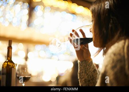 Femmina matura di bere il vino rosso in wine bar, Siviglia, Spagna Foto Stock